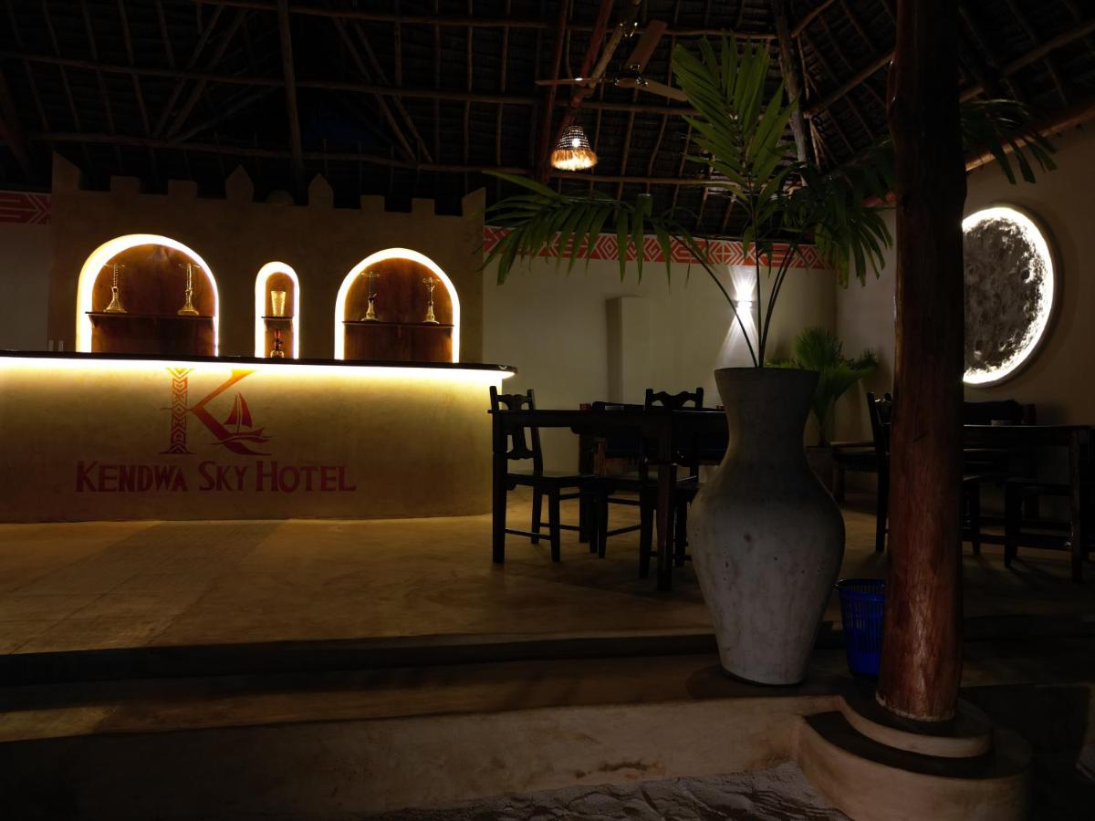 The hotel bar with arched alcoves, lit warmly beneath the thatch