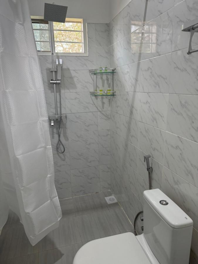 A tiled shower with a handheld fitting