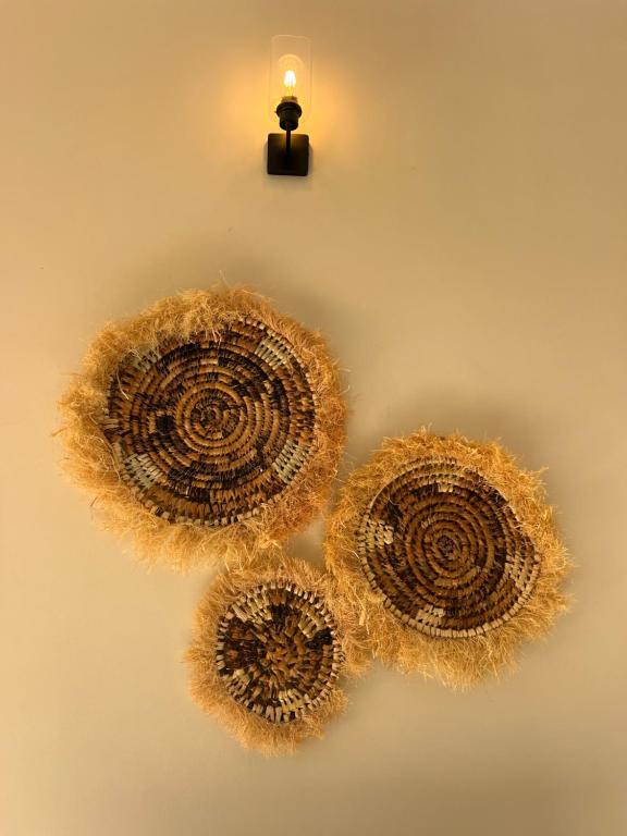Three woven raffia discs hung on a plain wall