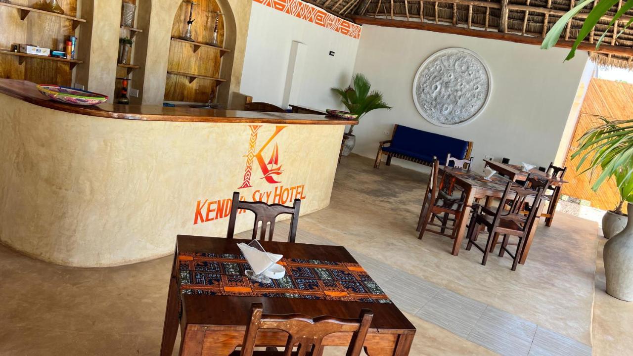 Carved wooden dining tables beside the logo wall