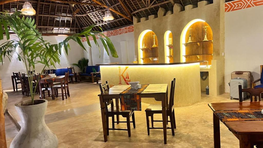 Dining tables set beneath the makuti thatch