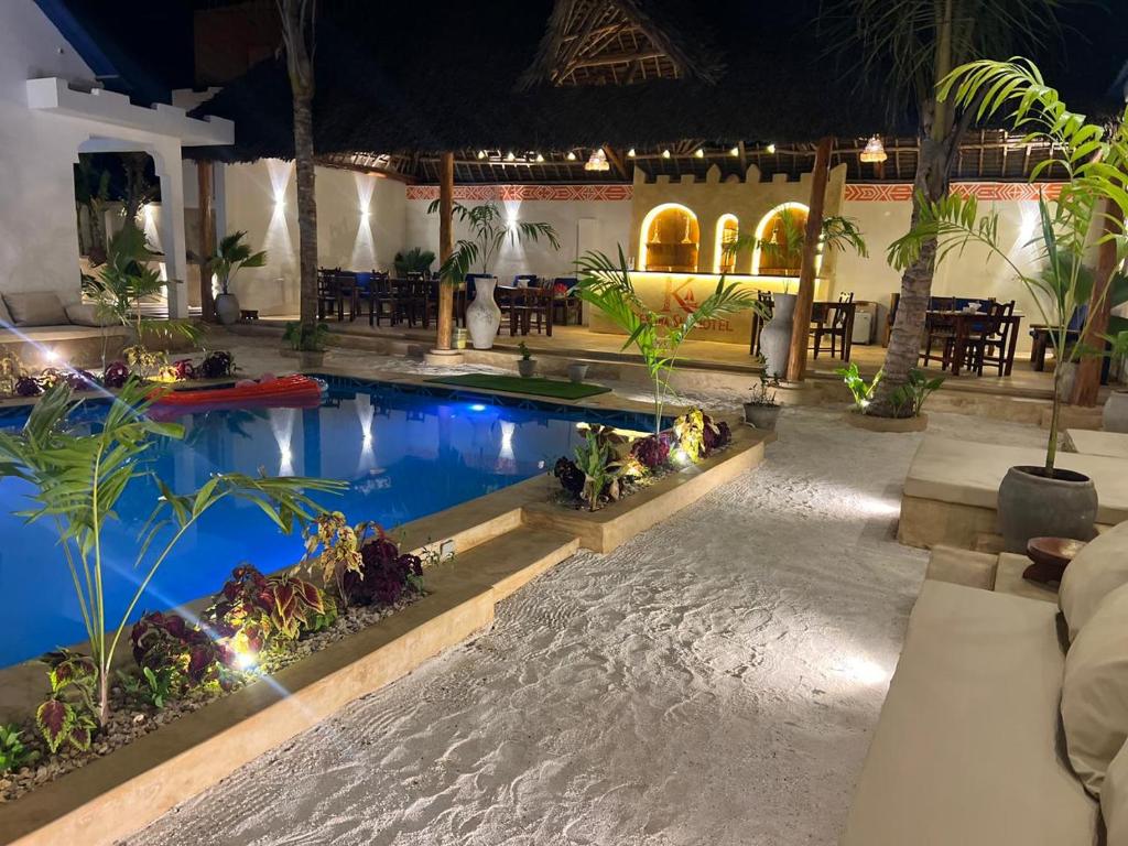The lit arched bar seen from across the pool at night