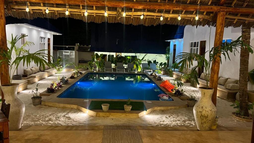 The courtyard, pool and thatch roof lit for the evening