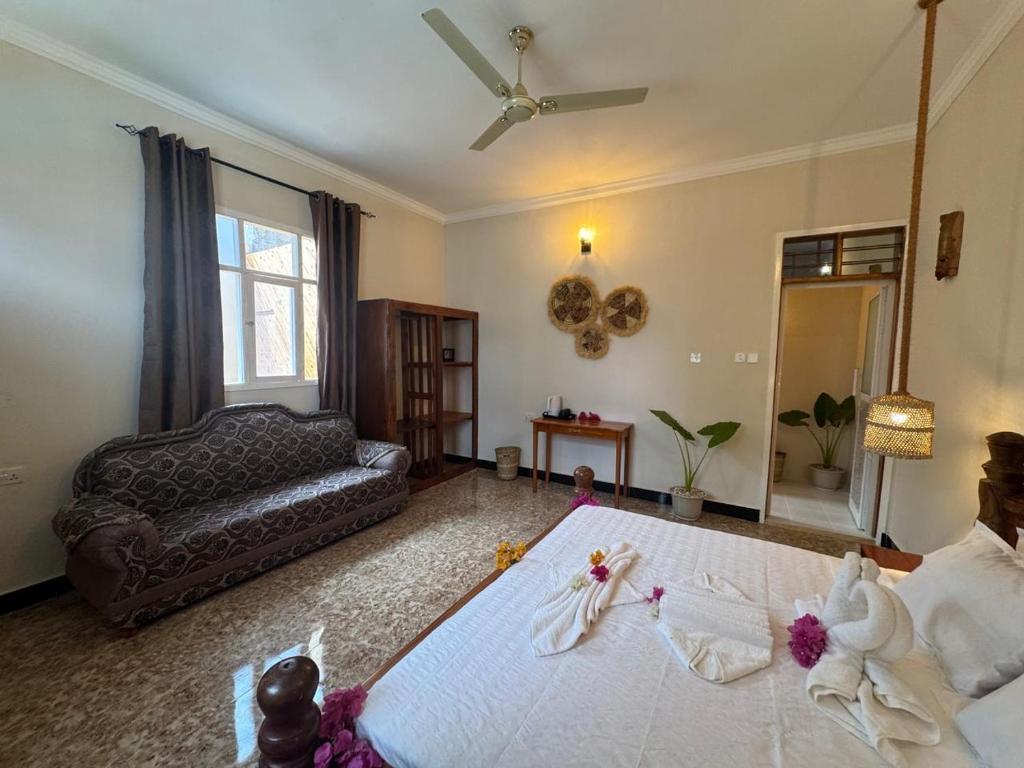 A guest room with a double bed, sofa and petals laid out