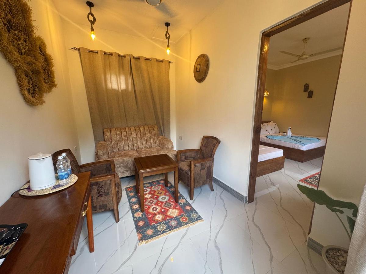 A guest room with a seating corner and patterned rug