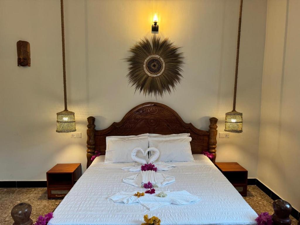 A bed with bedside lamps and a woven disc above the headboard
