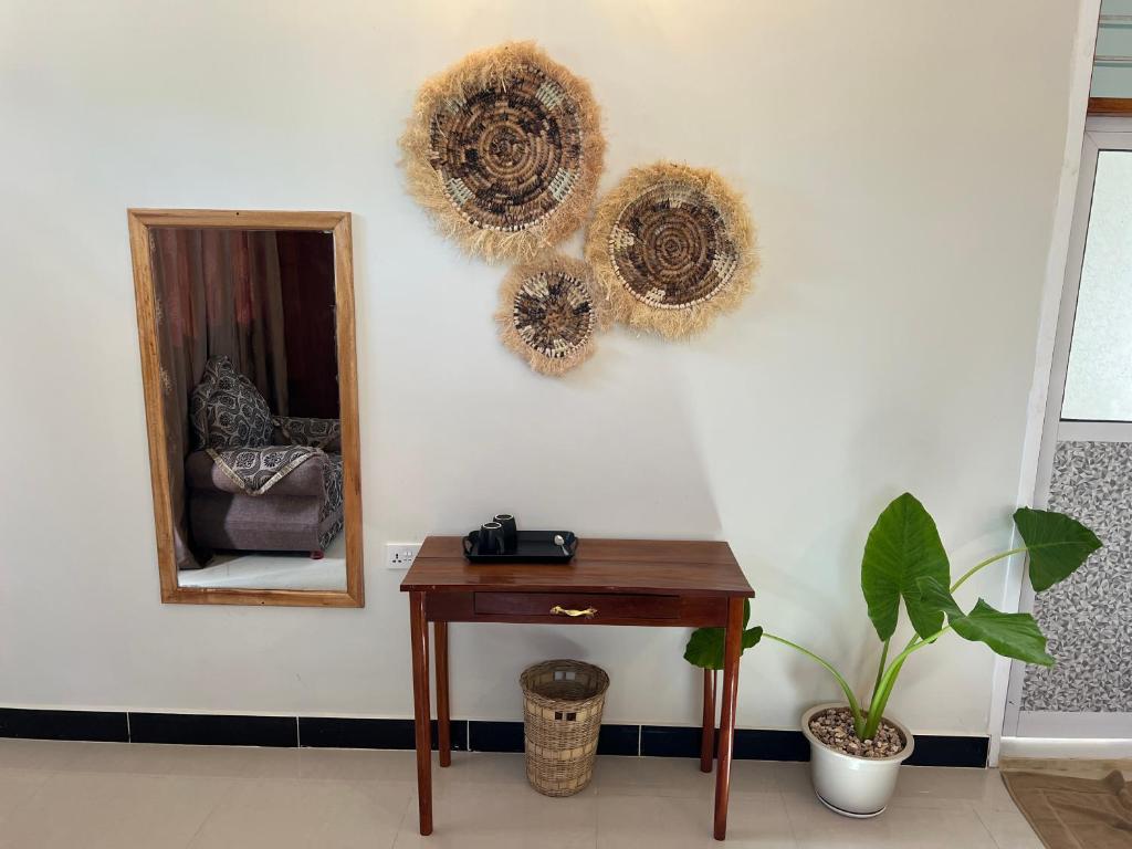 A wooden desk and mirror below woven wall discs