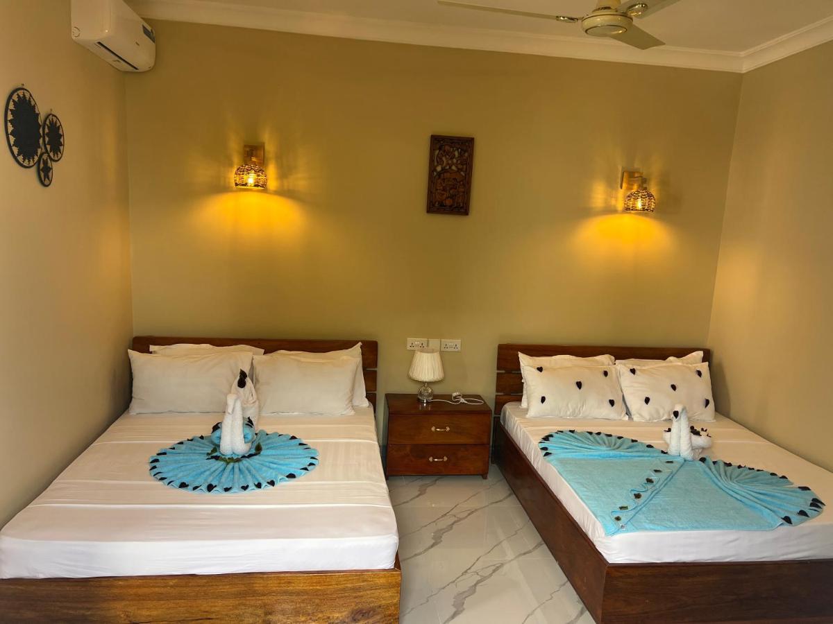 Two single beds made up with sea-green throws