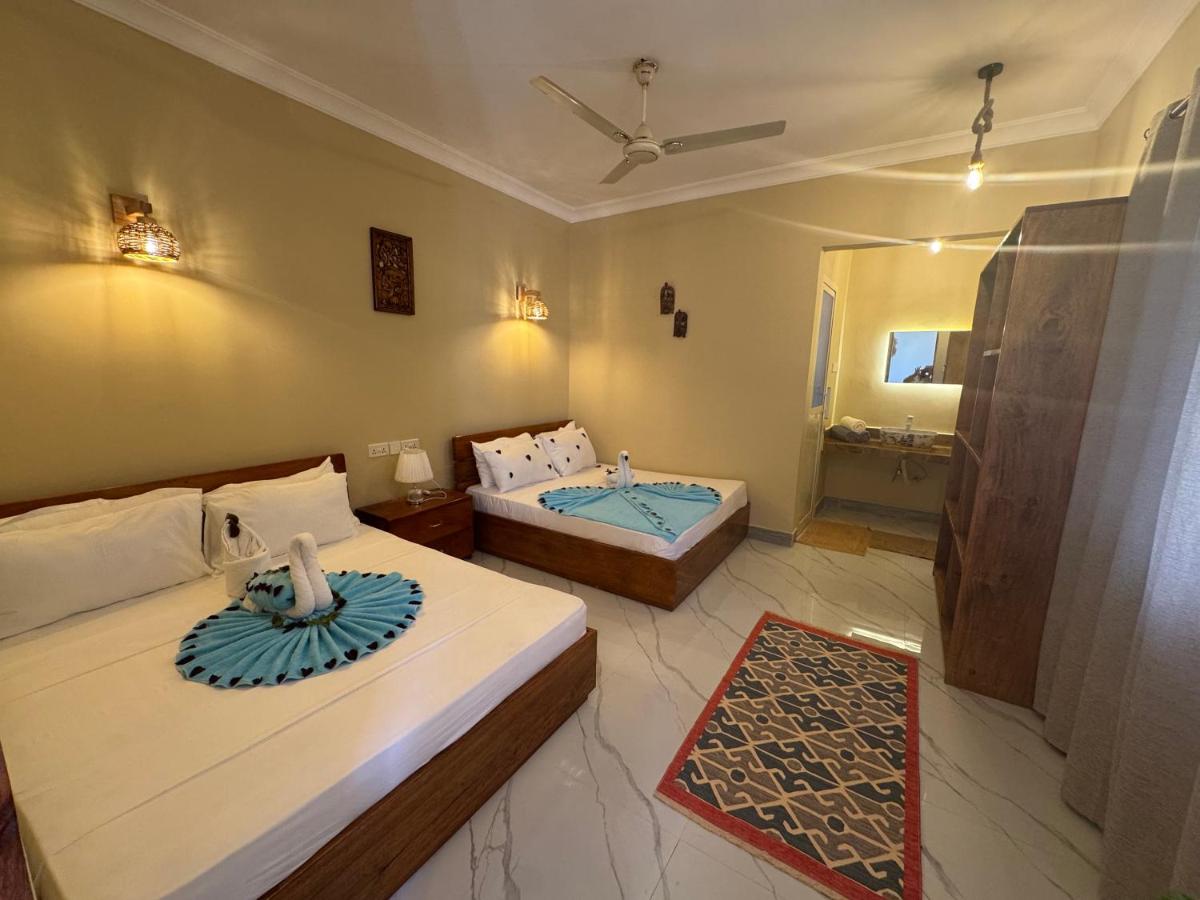 Twin beds dressed with teal throws and a rug